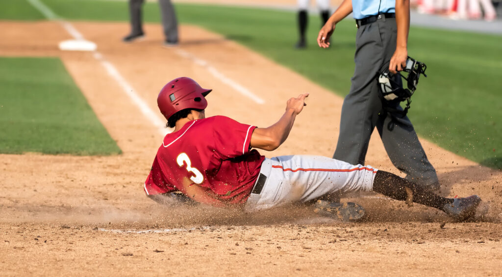 Baseball player sliding into home plate